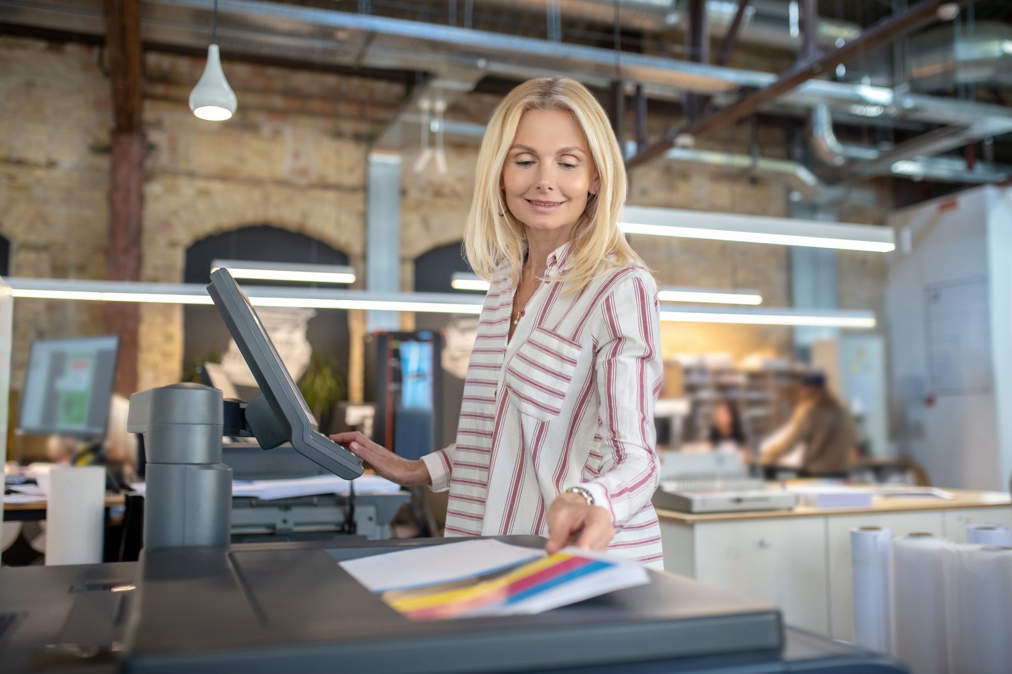 Blonde woman at a copy machine