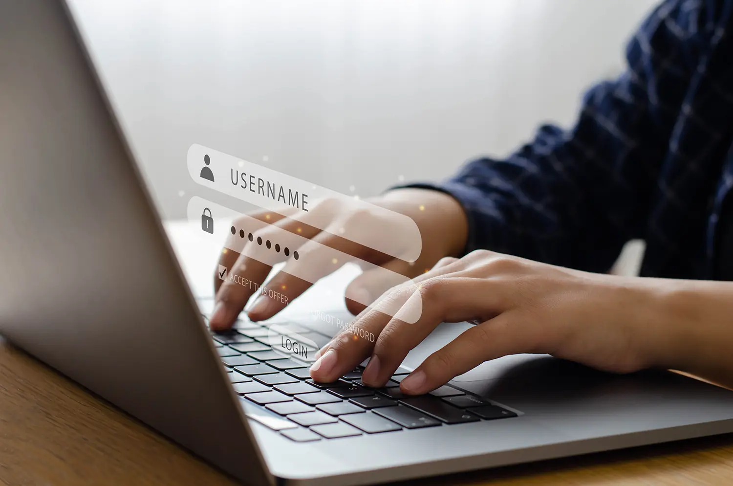 person at a laptop typing in their username and password