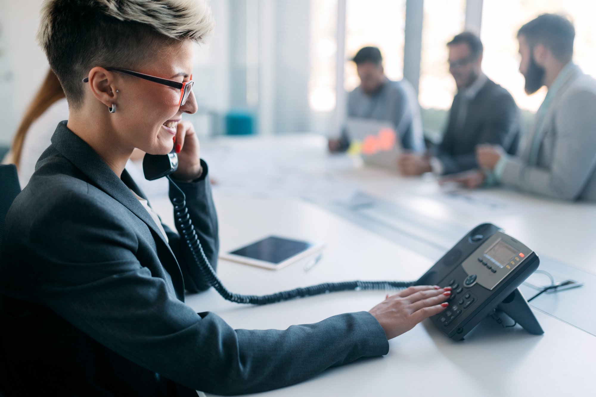 Woman using her VoiP phone system at work