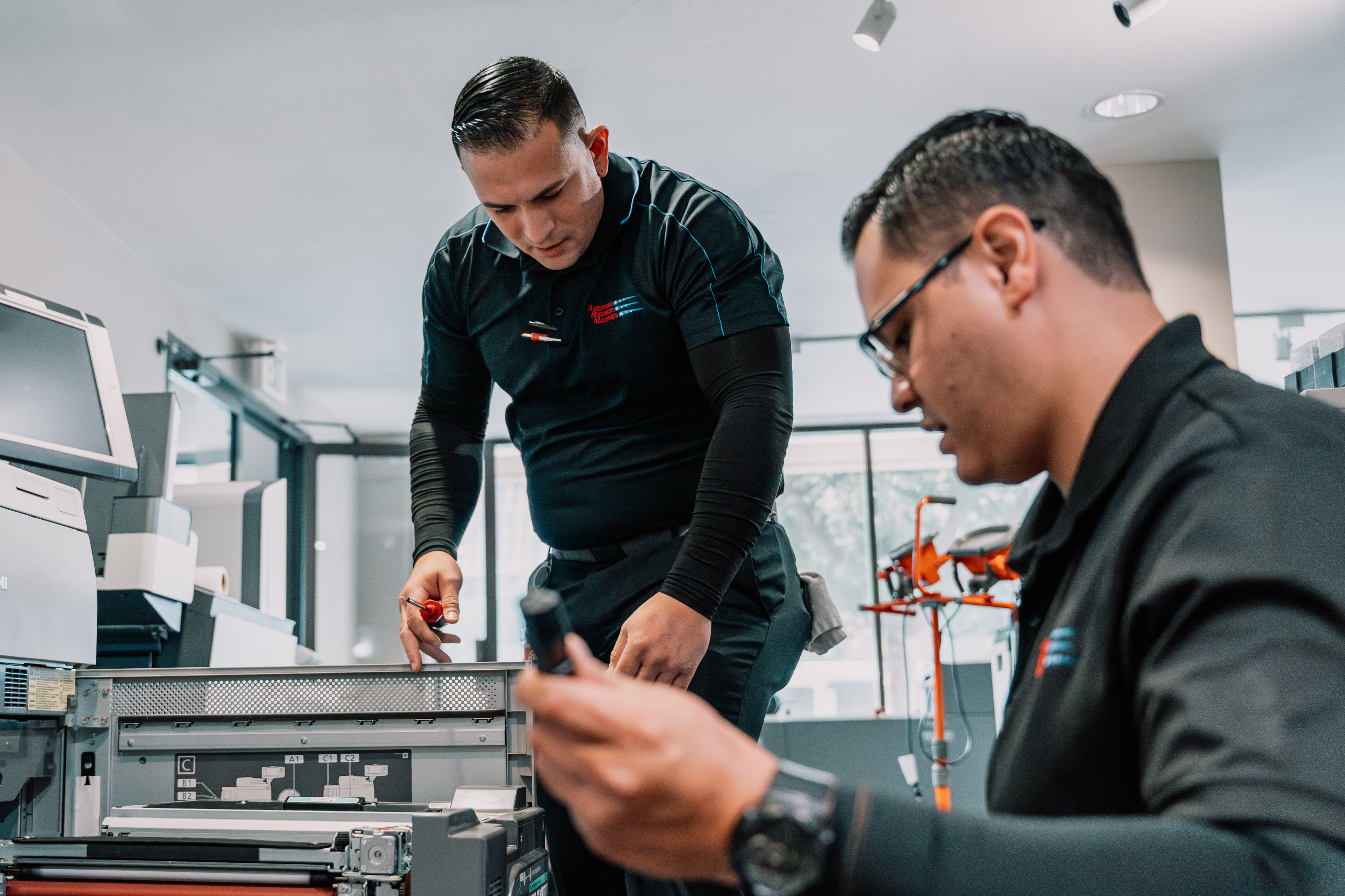 ABM service technicians inspect a Canon copier