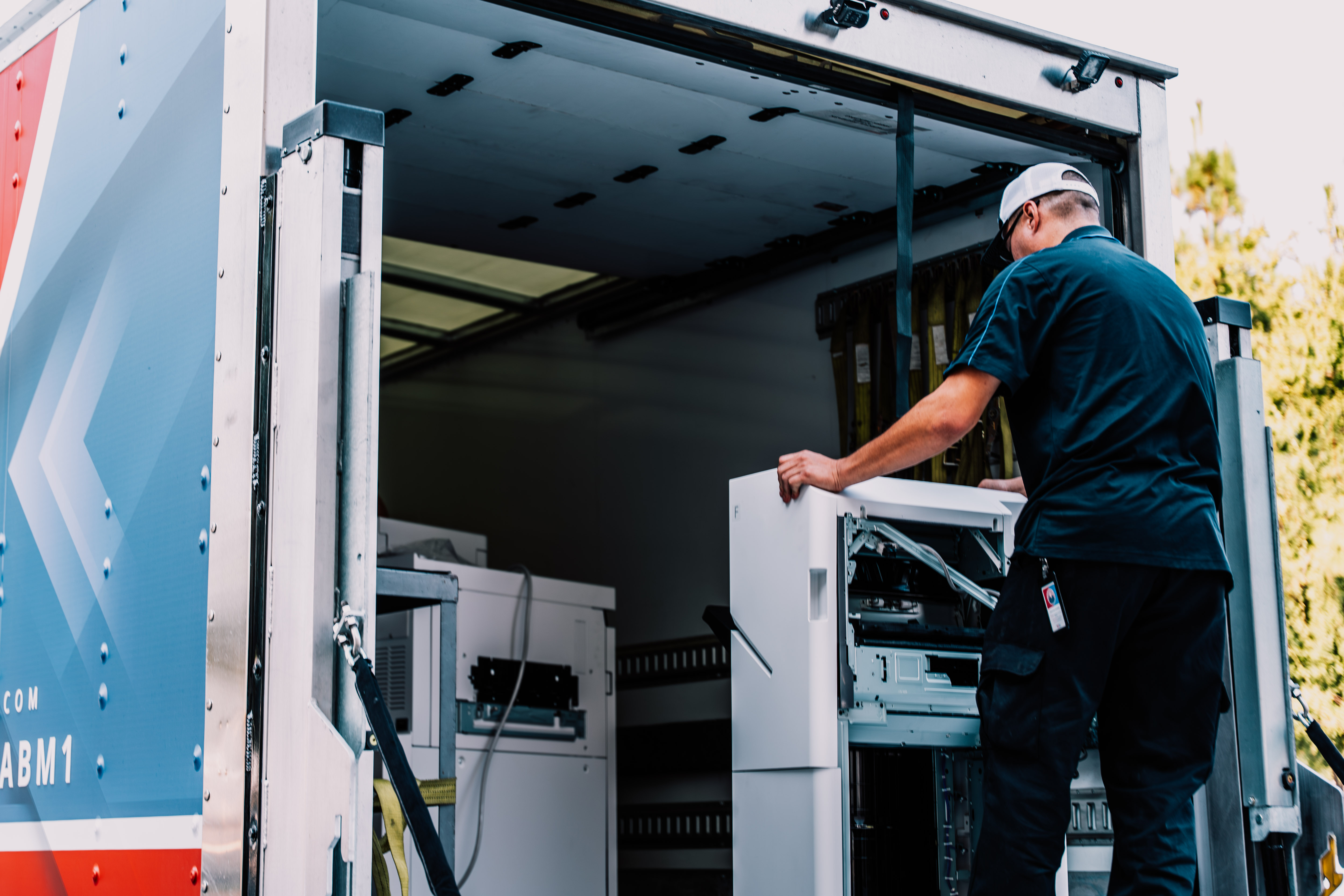 Employee delivering a copy machine to a business