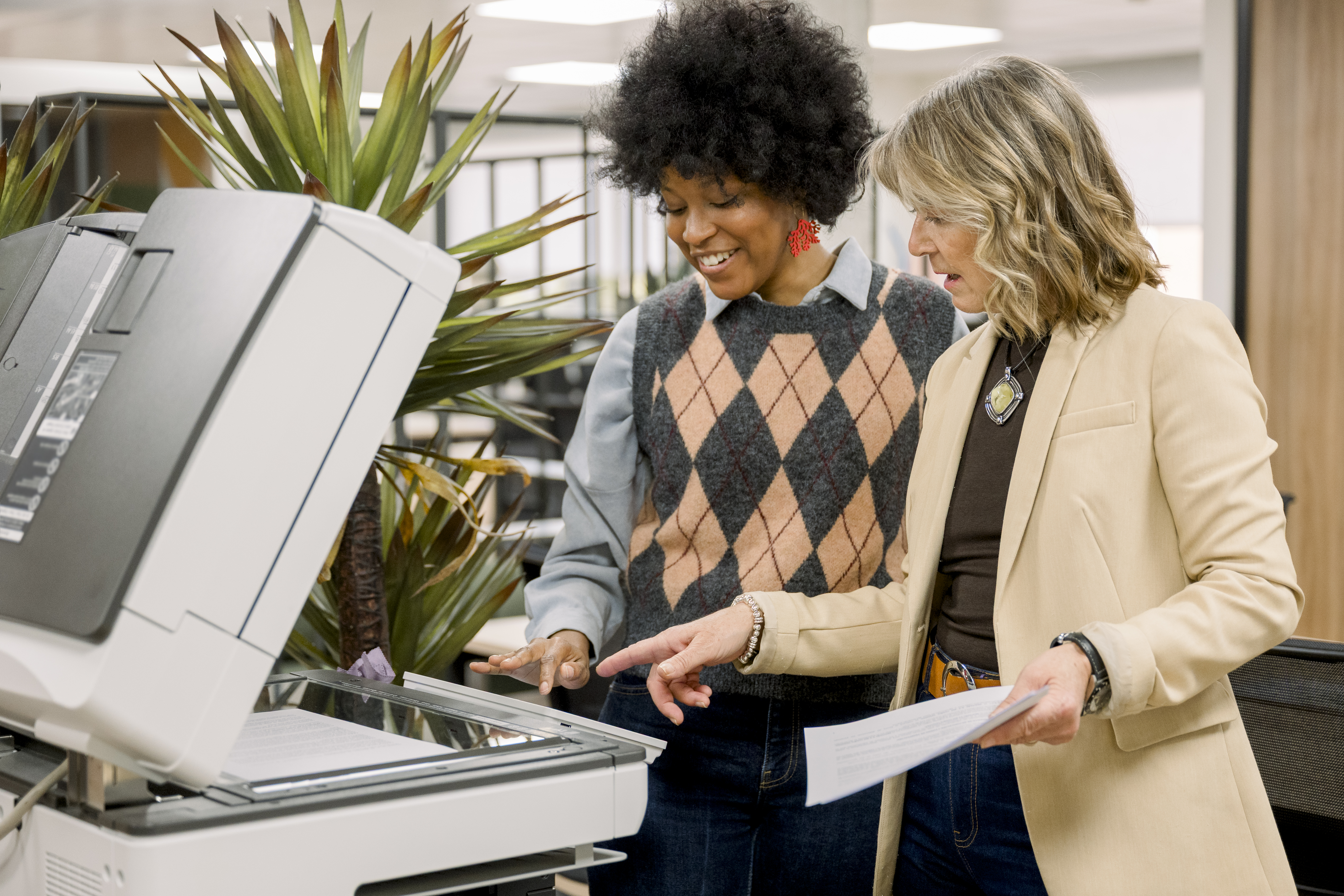 two coworkers use a copy machine
