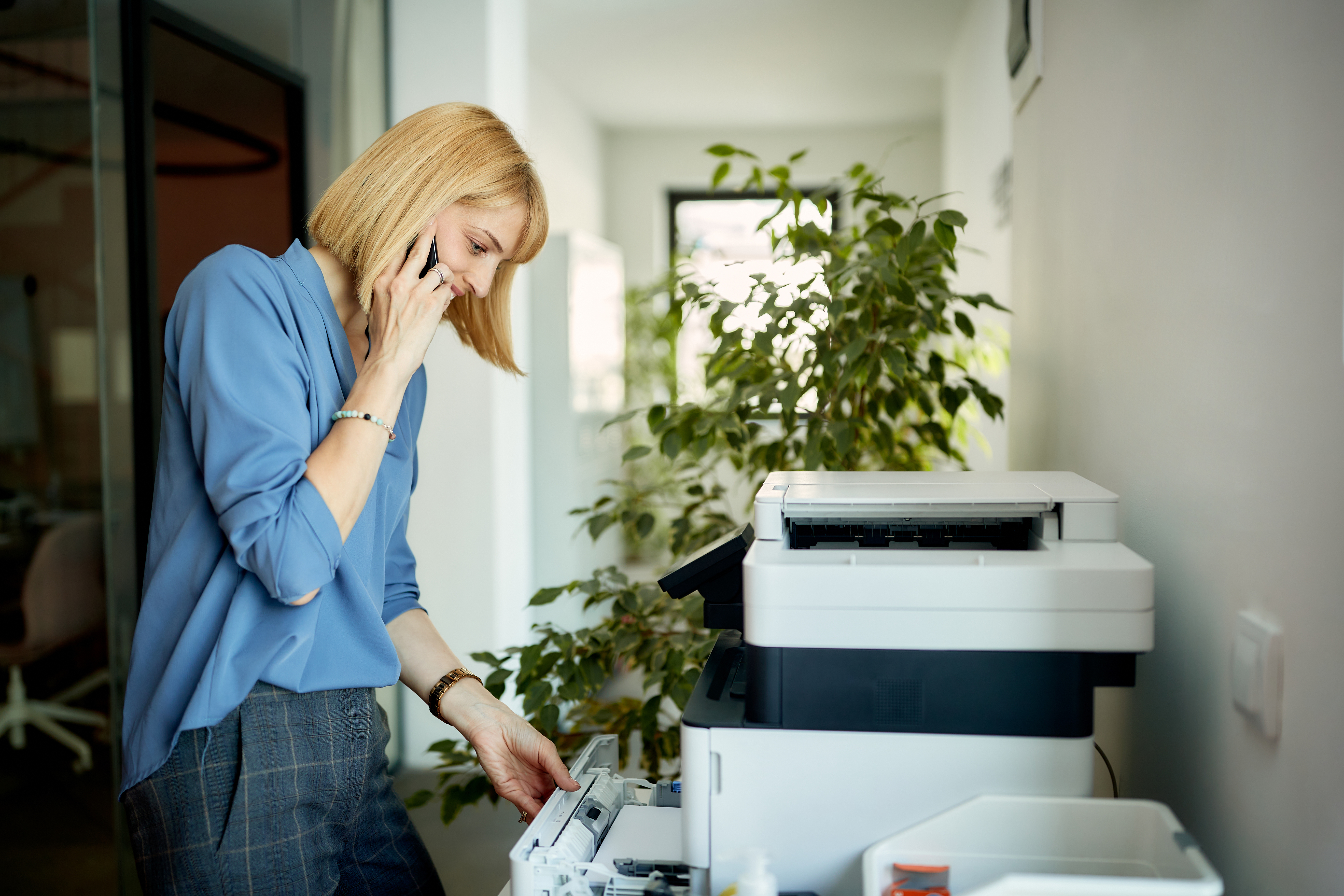 Copy machine being used by a woman in an office